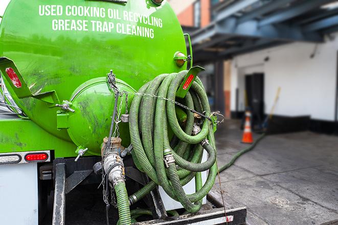 a technician pumping a grease trap in a commercial building in Maywood NJ